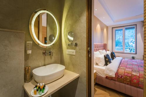 a bathroom with a sink and a bed and a mirror at Tripli Hotels Royal Spring in Mussoorie