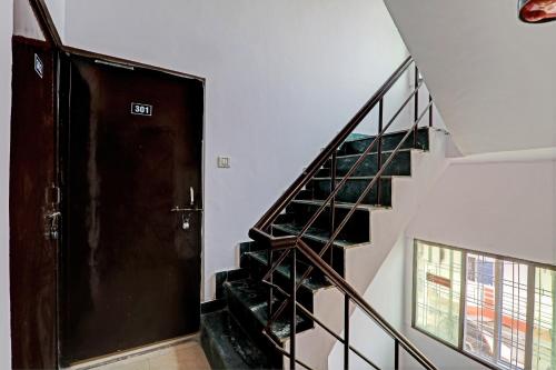 a hallway with a staircase with a door and a stair case at Hotel O Raama in Lucknow