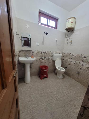 a bathroom with a toilet and a sink and a toilet istg at Vikas Hotel And Restaurant in Barot 