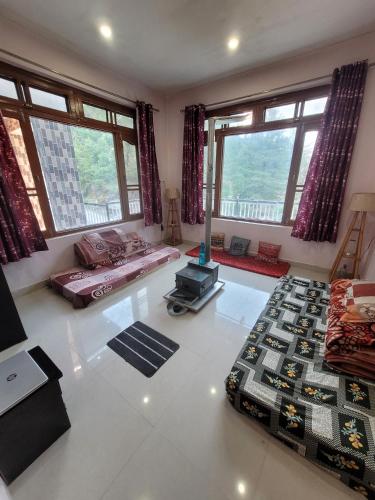 a large living room with two beds and windows at Vikas Hotel And Restaurant in Barot 