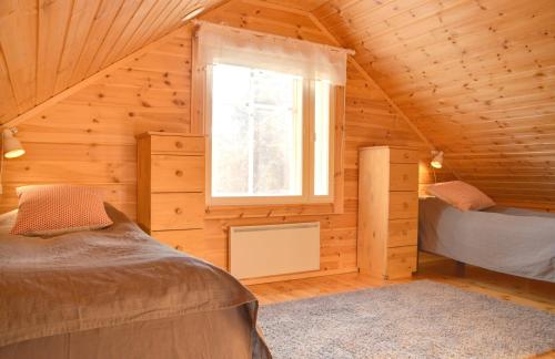 a log cabin with two beds and a window at PUTTITIE 4A in Tahkovuori
