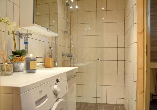 a bathroom with a shower and a toilet and a sink at PUTTITIE 4A in Tahkovuori