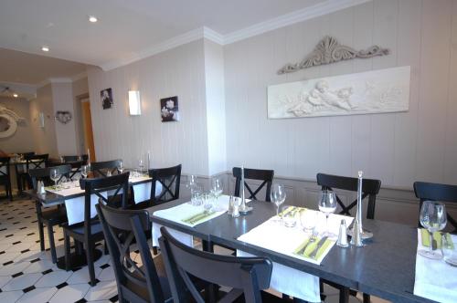 a dining room with tables and chairs with wine glasses at Cristal Hôtel Restaurant - Logis Hotels in Saumur
