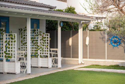 a house with white chairs on the front porch at Nautical Toroni Rooms in Toroni