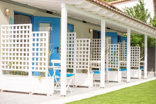 a white pergola with chairs and tables on a house at Nautical Toroni Rooms in Toroni