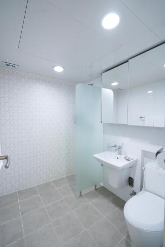 a white bathroom with a toilet and a sink at 프레지던트 신라연수원 in Gyeongju