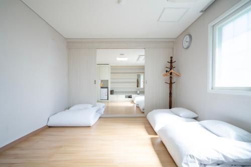 a white room with two beds and a window at 프레지던트 신라연수원 in Gyeongju