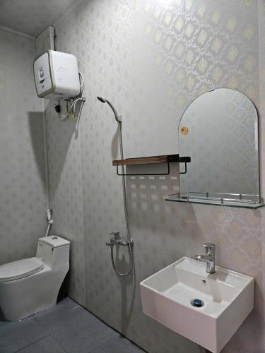 a bathroom with a sink and a toilet and a mirror at Hồ Mây Homestay in Bảo Lâm