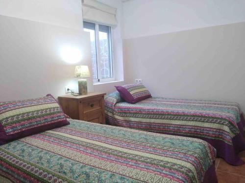 a bedroom with two beds and a window at Casa Galisa in Torrevieja