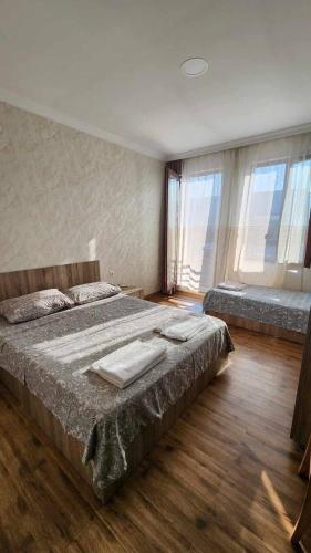 a bedroom with a large bed and two windows at Rio cottage apartment in Ureki