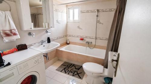 a bathroom with a tub and a toilet and a sink at Vens apartment 90m2 at Eantio bay. in Aiándion