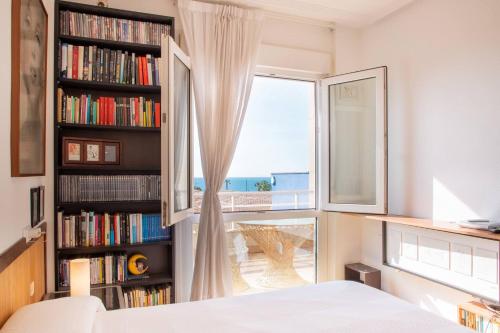 a bedroom with a window and a book shelf with books at Aguamarina Ático Duplex Gran Terraza Cabo Roig in Orihuela