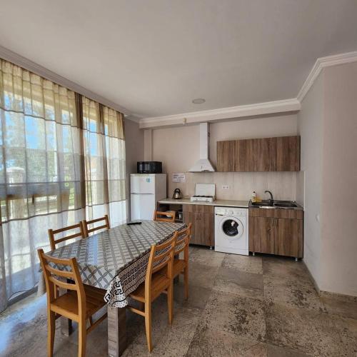 a kitchen with a table and chairs in a kitchen at Rio cottage apartment in Ureki