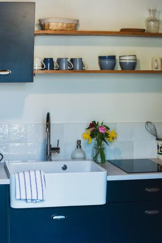 a kitchen with a sink and a vase of flowers at Gîte Sidonie in Apremont