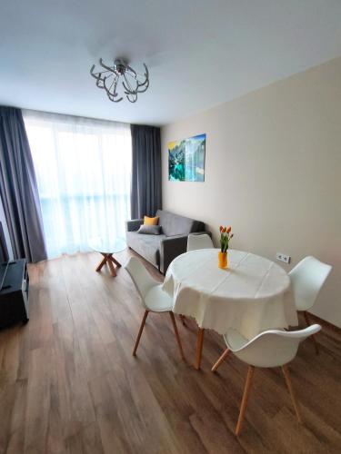 a living room with a table and chairs and a couch at Apartment in Chantrer Residence with garage in Burgas