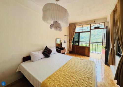 a bedroom with a bed and a chandelier at Ba Be Lake View Homestay in An Ma