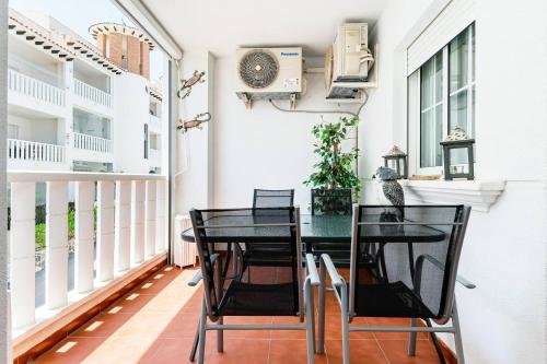 a dining room with a table and chairs on a balcony at Playa del Pinet Apartment in La Marina