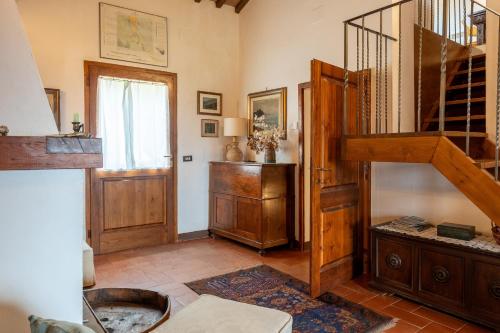 a living room with a wooden staircase and a window at Capanne di Sopra in Torrita di Siena