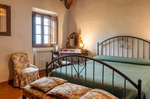 a bedroom with a bed and a chair at Capanne di Sopra in Torrita di Siena