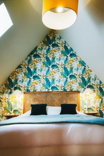 a bedroom with a large bed with a floral wallpaper at Gîte Sidonie in Apremont