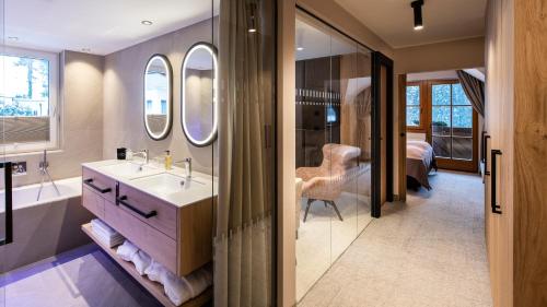 a bathroom with a sink and a mirror at Hotel Sonnalp 4 Sterne Superior in Obereggen