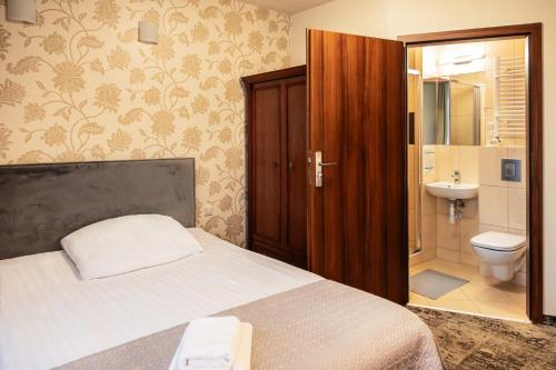 a bedroom with a bed and a sink and a toilet at Villa Solaris in Niechorze