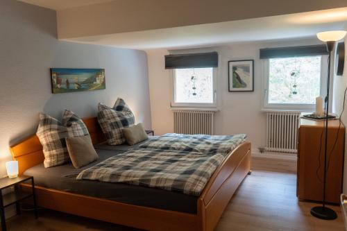 a bedroom with a bed and two windows at Ferienwohnung Belchenzeit in Münstertal