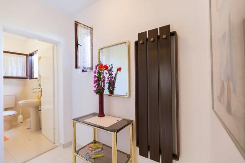a bathroom with a vase of flowers on a table at House on the sea in Preko