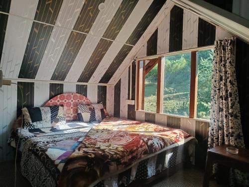 a bedroom with a bed in a room with a window at BAKSHI lodge in Pahalgām