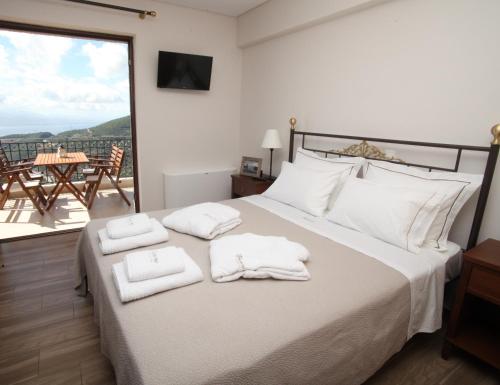 Treanto Nafpaktos Boutique Hotel في نافباكتوس: غرفة نوم بسرير كبير عليها مناشف