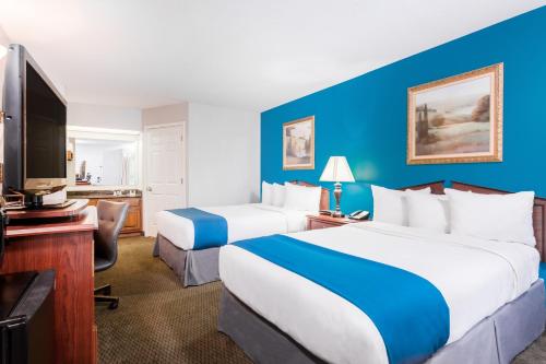 a hotel room with two beds and a flat screen tv at Baymont by Wyndham Duncan/Spartanburg in Duncan