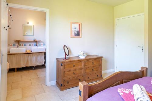 a bedroom with a bed and a wooden dresser at La Jouanhitte in Bourrouillan