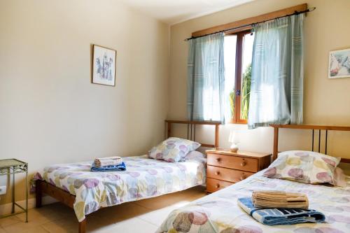 a bedroom with two beds and a window at La Jouanhitte in Bourrouillan