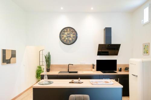 a kitchen with a sink and a clock on the wall at Gite de Laluby in Arx