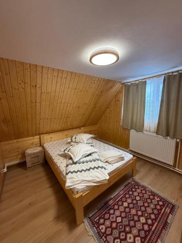 a bedroom with a bed in a wooden room at Cabana Daria in Gârda de Sus