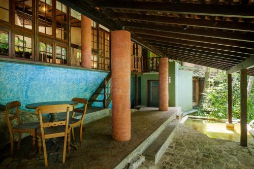 a room with a table and chairs in a building at Sama Retreats - Kosgoda in Kosgoda