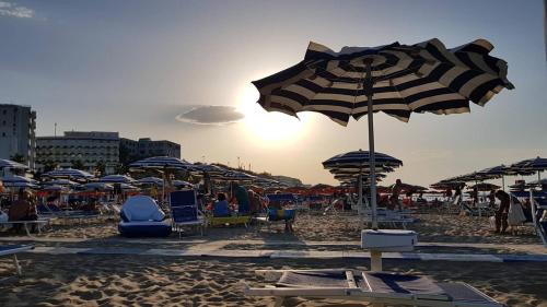a beach with a bunch of umbrellas and chairs at Centro & Mare - Rooms - Garage - Suites in Termoli