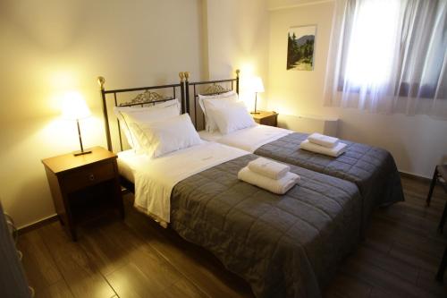 a bedroom with a bed with two towels on it at Treanto Nafpaktos Boutique Hotel in Nafpaktos