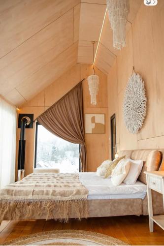 a bedroom with a large bed and a large window at Boho Shale in Yablunytsya