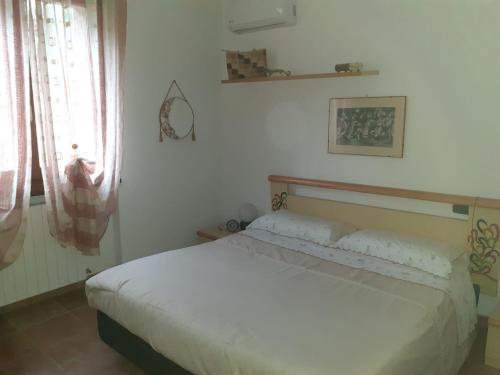 a bedroom with a white bed in a room at Bellavista Coghinas in Oschiri