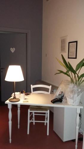 a white desk with a lamp and a plant at Corte Mantovani in Colà di Lazise