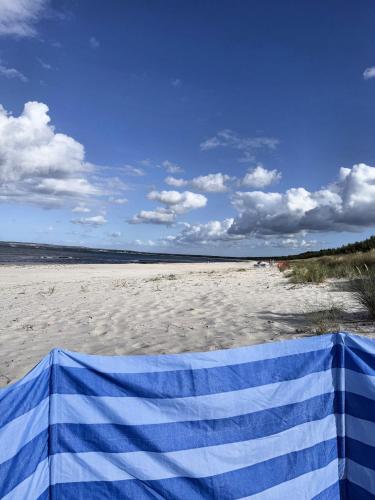 a blue and white towel on a sandy beach at Ferienwohnung Sonnenschein in Dranske