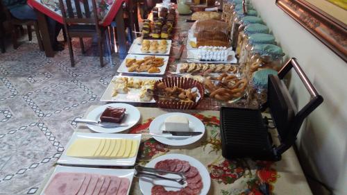ein langes Buffet mit verschiedenen Arten von Speisen in der Unterkunft Pousada Charme da Serra in Bom Jardim da Serra