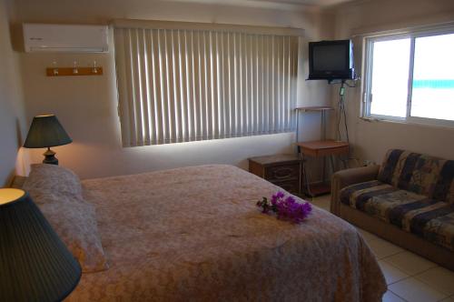 a hotel room with a bed and a couch at Pescadero Palace in El Pescadero