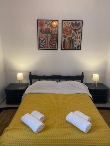 a bedroom with a yellow bed with two towels on it at Της κυρα Τασιας in Konitsa