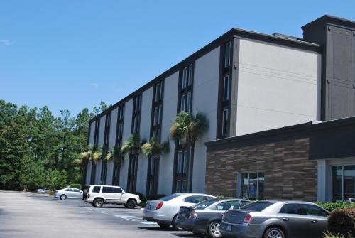 a parking lot with cars parked in front of a building at Wyndham Garden Summerville in Summerville