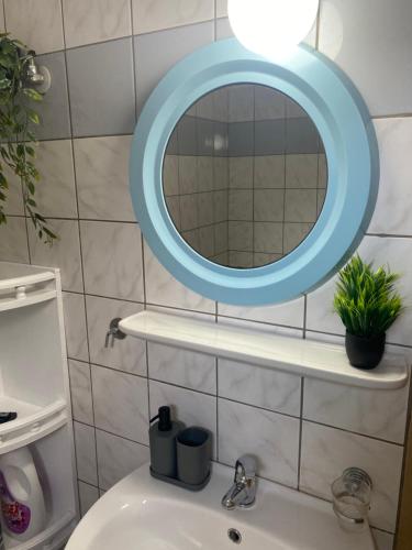 a bathroom with a blue mirror above a sink at Της κυρα Τασιας in Konitsa
