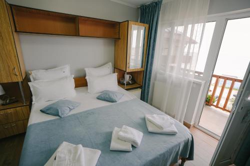 a bedroom with a bed with two towels on it at Hotel Sunset Beach Vama Veche in Vama Veche