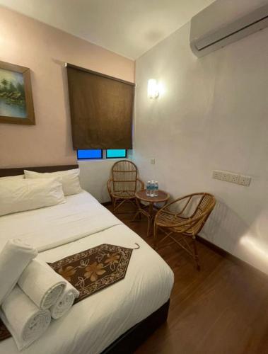a hotel room with a bed and a table at Hotel O Village in Baling