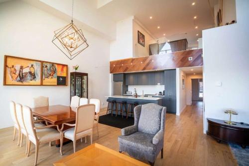 a kitchen and dining room with a table and chairs at 408 - Modern Condo - Pool & Panoramic View in Baie-Saint-Paul